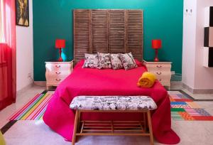 1 dormitorio con 1 cama grande con manta rosa en Apartamento POP-ART, junto a la Plaza Mayor, by My Home in Salamanca, en Salamanca