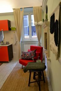 a living room with a red chair and a fireplace at BoHome in Chieti +2 photos