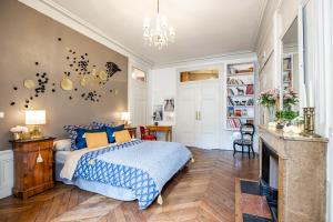 a bedroom with a bed and a fireplace at Appartement Haussmannien d’Artiste, exception, quai de Saône balcon+Parking in Lyon