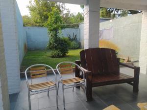 duas cadeiras e um banco num pátio em Casas Arena y Sol - FRENTE AL MAR em Parque del Plata