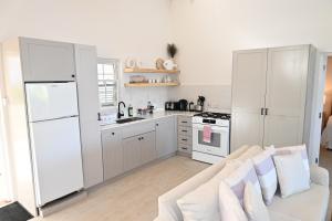 a white kitchen with a couch and a white refrigerator at Little Good Harbour in Saint Peter