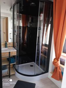 um chuveiro com uma porta de vidro na casa de banho em Ty-Reviens em Lanrivoaré