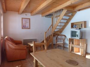a living room with a wooden staircase and a table at A&B Bungalovy in Morávka