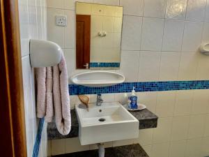 uma casa de banho com um lavatório e um espelho em Cliff’s Apartment em Dar es Salaam