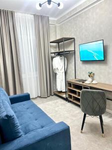 salon z niebieską kanapą i telewizorem w obiekcie Urban Hotel w mieście Biszkek