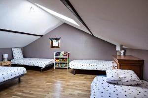 a attic room with two beds and a book shelf at Charmant gîte Bourguignon in Saint-Marcel