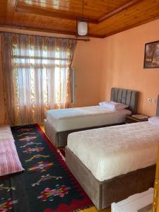 a hotel room with two beds and a window at Vila Llulla in Krujë