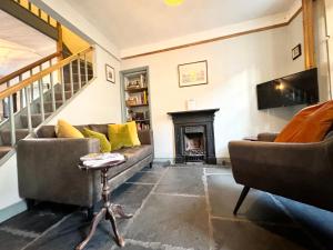 a living room with two couches and a fireplace at The Old Locksmith Cottage, Ulverston - Lake District in Ulverston