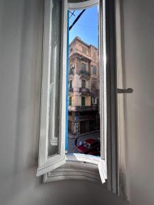 une fenêtre ouverte avec vue sur un bâtiment dans l'établissement Alexandria private rooms at Shared apartment, Only Men Guests 仅限男士, à Alexandrie