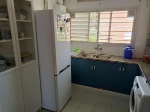 Una cocina con un refrigerador blanco y un fregadero. en Apartamento al lado de Barcelona y la playa, en Montgat