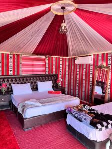 a bedroom with two beds in a tent at Rum luxury star in Wadi Rum