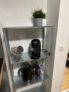 a metal shelf with a coffee maker on it at Modern living: Stylish one-bedroom flat in Hockenheim