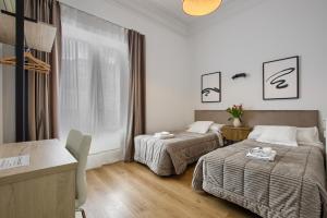 ein Hotelzimmer mit 2 Betten und einem Tisch in der Unterkunft Hostal Besaya in Madrid