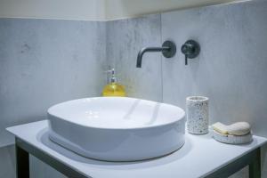 een badkamer met een witte wastafel in een kamer bij Studio Suite Mirakul in Komiža