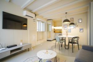 een woonkamer met een tafel en stoelen in een kamer bij Studio Suite Mirakul in Komiža