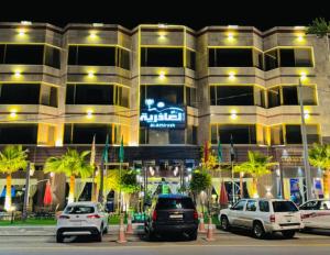 a building with cars parked in front of it at ليالي العاذرية للوحدات السكنية in Al Namas