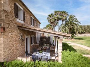 a stone house with a table and chairs on a patio at Casa Torrent by Finca Es Torrent in Campos