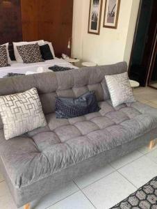 a gray couch with pillows in a living room at Belo Flat Resort Lake Side Beira Lago in Brasília