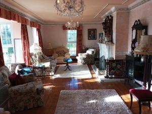 uma sala de estar com mobiliário e um lustre em Kiltubber House em Kinnegad