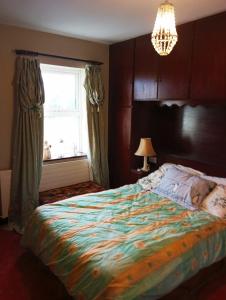 a bedroom with a bed and a window and a chandelier at Kiltubber House in Kinnegad
