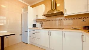 a kitchen with white cabinets and a microwave at Click&Guest - Blue Marine in Playa del Hombre in Telde