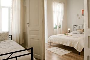 1 dormitorio con 2 camas y ventana en Lilian's House, en La Canea