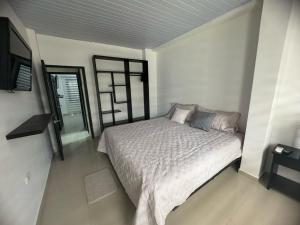 1 dormitorio con 1 cama y TV en Casa En Leticia, en Leticia