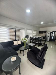 ein Wohnzimmer mit einem Sofa, Stühlen und einem Tisch in der Unterkunft Casa En Leticia in Leticia