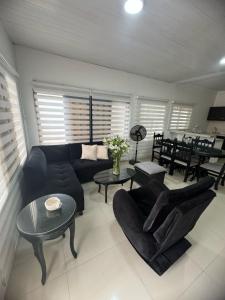 ein Wohnzimmer mit einem Sofa, Stühlen und einem Tisch in der Unterkunft Casa En Leticia in Leticia