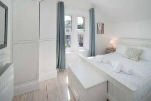 een witte kamer met een groot wit bed en een raam bij Solent View, 3bed apartment, fantastic sea views in West Cowes