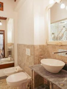 ein Badezimmer mit Waschbecken, Toilette und Spiegel in der Unterkunft Villa Peramonda in Fiesole