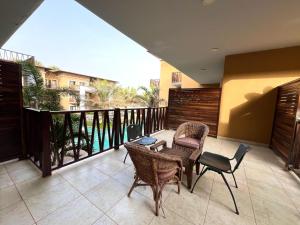 a patio with chairs and tables and a balcony at FOREST VIEW LUXURY APARTMENT in 3mins walk to beach pool view wifi in Kololi