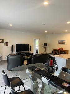 a living room with a couch and a table and chairs at A Cut Above Lodge - The Gateway to the Bay of Islands in Kerikeri