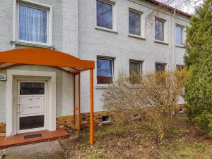 een oranje beschutting voor een gebouw bij Ferienwohnung Jänschwalde in Jänschwalde Ost