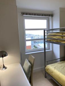 um quarto com um beliche, uma mesa e uma janela em Spinnaker apartment, 3bed with incredible views em East Cowes