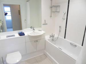 uma casa de banho branca com um lavatório e um chuveiro em Spinnaker apartment, 3bed with incredible views em East Cowes