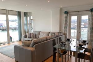 uma sala de estar com um sofá e uma mesa em Spinnaker apartment, 3bed with incredible views em East Cowes