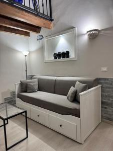 ein Sofa im Wohnzimmer mit Spiegel in der Unterkunft GDM central apartment Palermo in Palermo