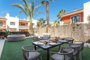 a patio with a table and chairs on the grass at Host Wise - Deluxe Spacious House with Terrace & Jacuzzi in Portimão