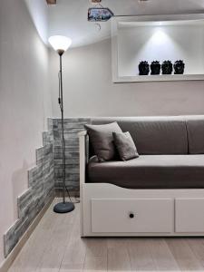 ein Wohnzimmer mit einem Sofa und einer Lampe in der Unterkunft GDM central apartment Palermo in Palermo