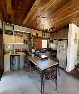 eine Küche mit Holzdecke und Holztisch in der Unterkunft Casa confortável em condomínio in Barra Grande