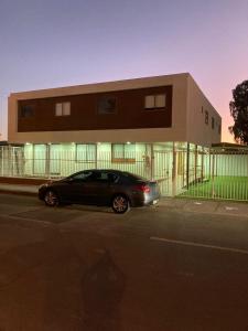Hostal Enerugi في كالاما: سيارة سوداء متوقفة أمام مبنى
