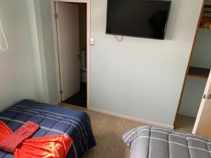 a bedroom with a bed and a flat screen tv on the wall at Hostal Enerugi in Calama