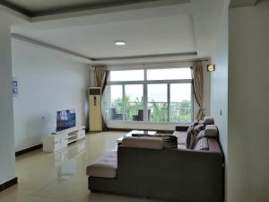 a living room with a couch and a large window at BleVaMa Ocean View Home in Dar es Salaam