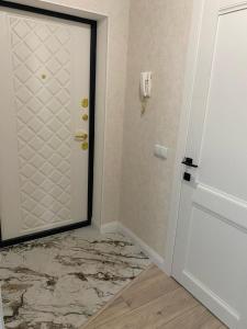 Una puerta en una habitación con suelo de mármol en Apartaments COSTA ЖК Тандау en Astaná
