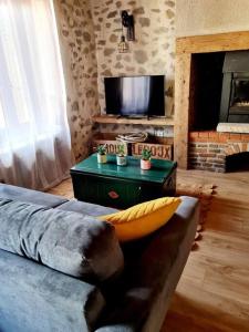 a living room with a couch and a television at Au coin des amis in Aurillac