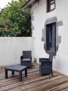 - une terrasse avec 2 chaises et une table basse dans l'établissement Au coin des amis, à Aurillac