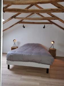 a bedroom with a bed and two lamps onlishes sidx sidx sidx sidx at Au coin des amis in Aurillac