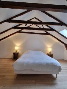 a bedroom with a white bed and two lamps at Au coin des amis in Aurillac