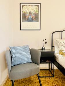 sypialnia z krzesłem i łóżkiem ze zdjęciem w obiekcie La Terrazza di Sant'Agata w Katanii